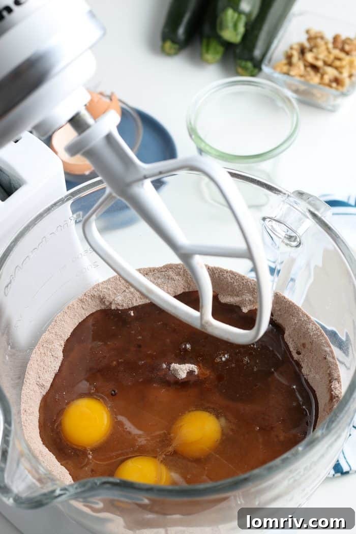 Mixing wet ingredients into dry ingredients for chocolate zucchini cake batter.