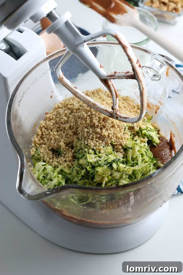 Adding shredded zucchini and chopped walnuts to chocolate cake batter.