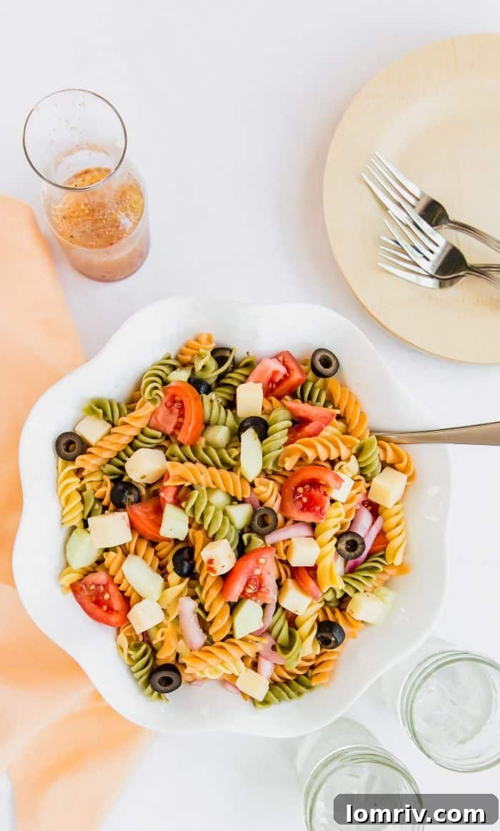 A bowl of vibrant summer pasta salad, garnished and ready to be served