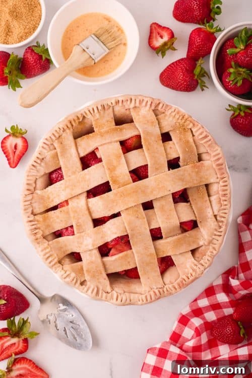 Homemade strawberry pie with a beautifully woven lattice top crust, ready for the oven.