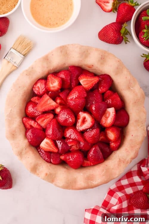 Homemade strawberry pie filling generously spooned into the prepared crust, mounded in the center.