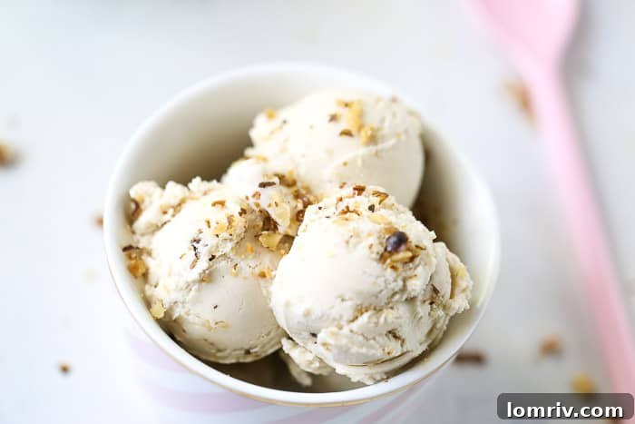 Close-up of creamy Banana Walnut Cheesecake Ice Cream in a bowl, showcasing its smooth texture and walnut pieces.
