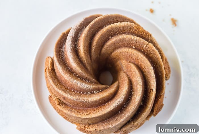 A beautifully presented slice of Snickerdoodle Bundt Cake on a white plate