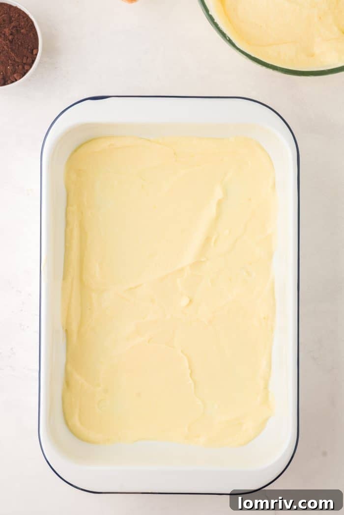 Spreading the first layer of mascarpone cream in a pan