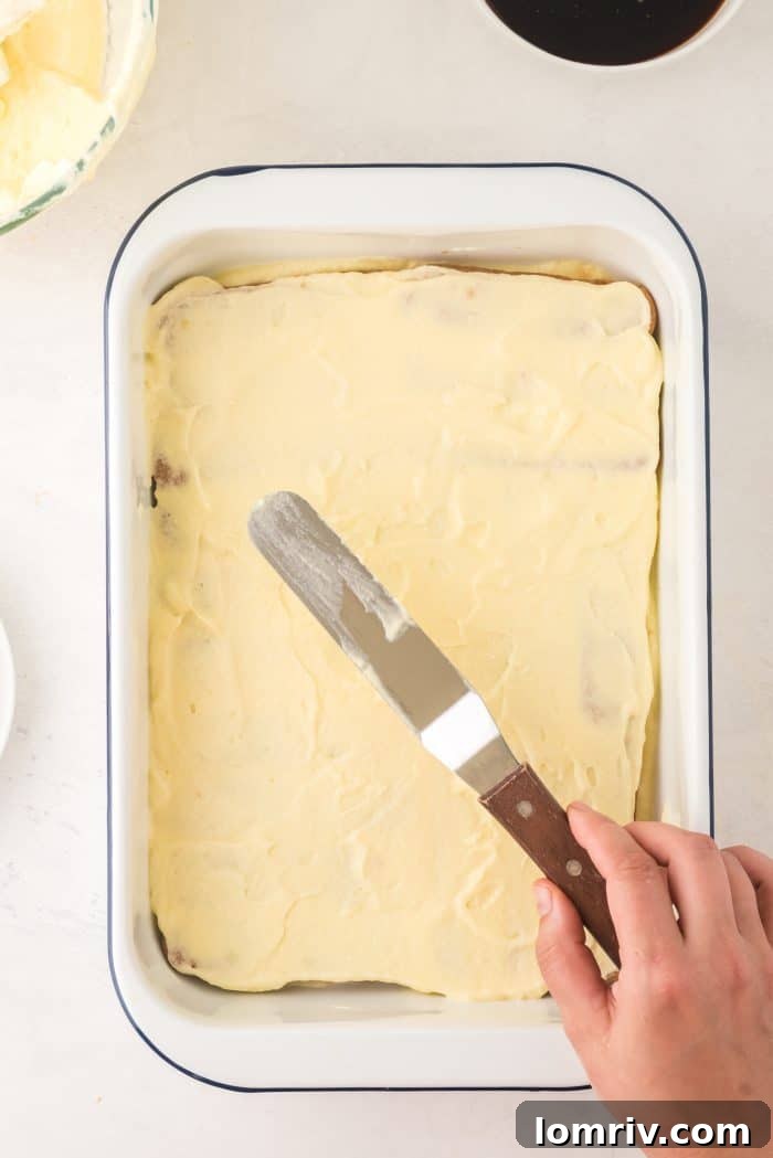 Adding a second layer of mascarpone cream over ladyfingers