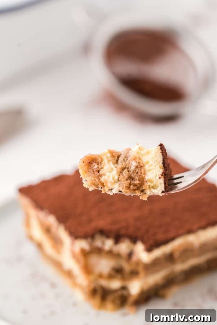 Slice of Tiramisu on a plate with coffee in the background