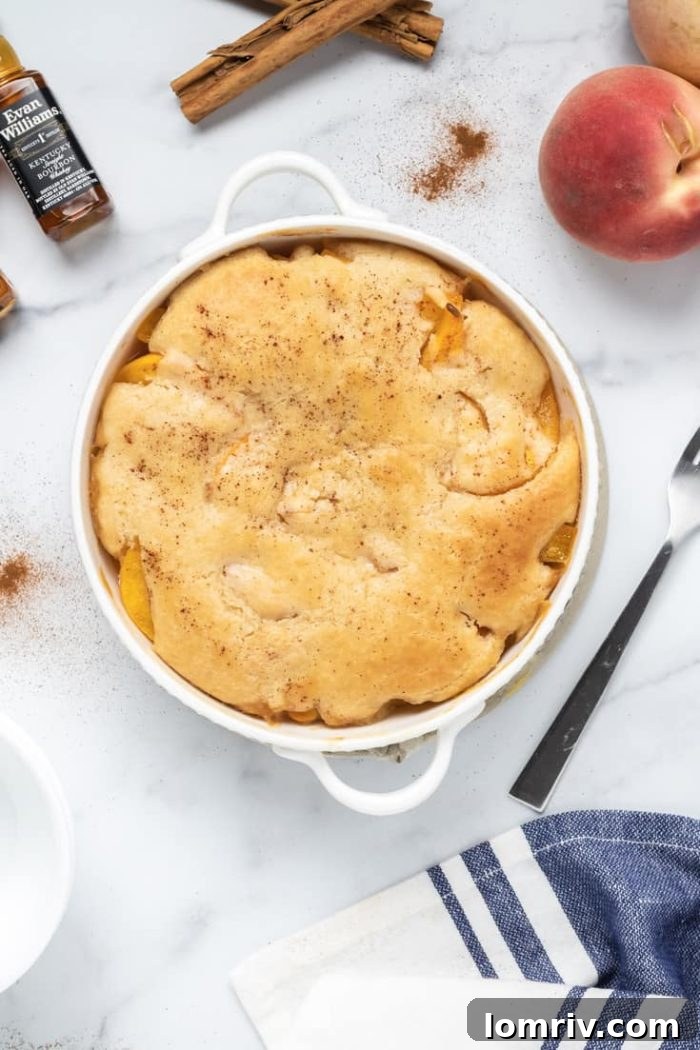 Bourbon Peach Cobbler - Golden brown biscuit topping over juicy spiced peaches