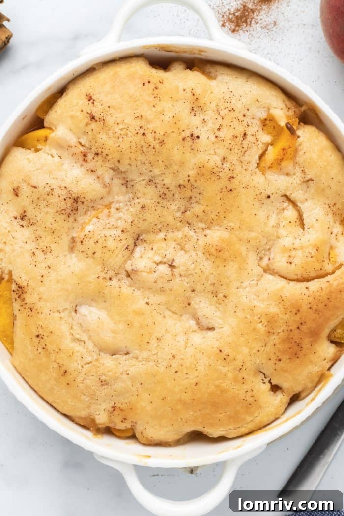Close-up of Bourbon Peach Cobbler with golden biscuit crust