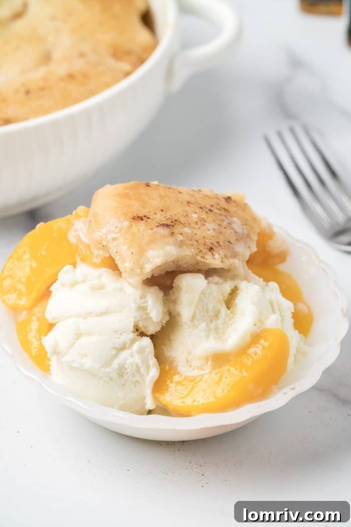 Serving Bourbon Peach Cobbler with a scoop of vanilla ice cream