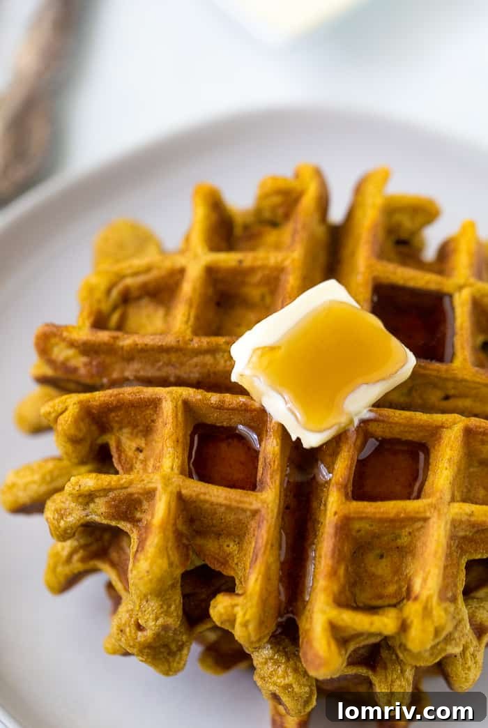 Buttermilk Pumpkin Waffles - A stack of golden, fluffy pumpkin waffles with a hint of spice, ready for maple syrup.