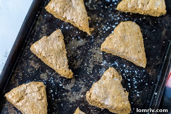 Brushing pumpkin scones with milk and sprinkling sugar