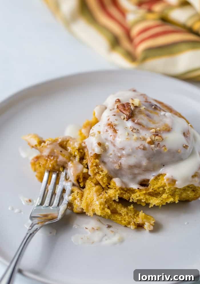Multiple freshly baked Pumpkin Cinnamon Rolls on a white platter, waiting to be served
