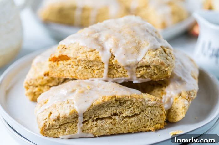 Stack of sweet potato scones with maple icing on a white plate