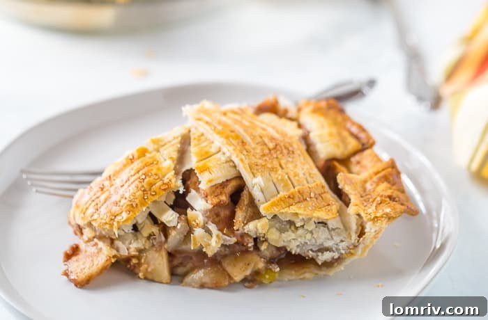 A slice of Pear Apple Pie served with a scoop of vanilla ice cream