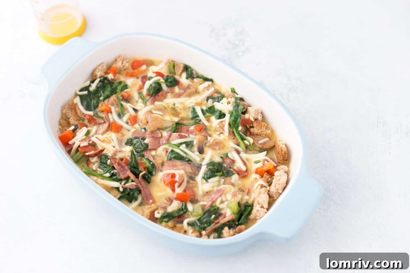 Cooking turkey bacon and chicken sausage in a skillet for breakfast casserole