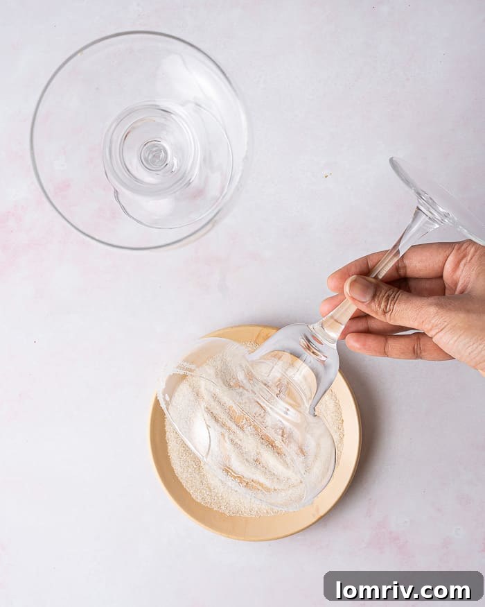 A hand squeezing fresh grapefruit juice into a measuring cup, highlighting the fresh ingredient preparation.