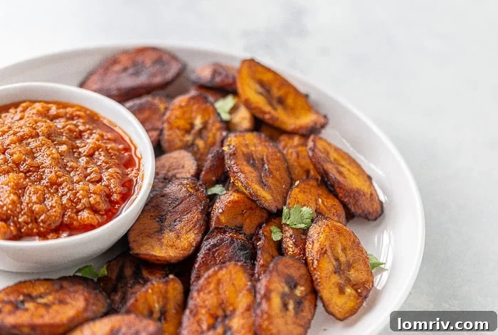 Freshly fried plantains served with a bowl of hot pepper sauce