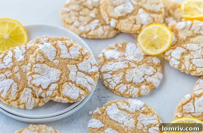 A baker's hand holding a Meyer Lemon Crinkle Cookie, showing its soft interior and vibrant color.