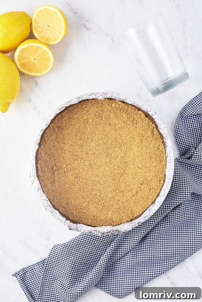 A springform pan with a perfectly pressed graham cracker and coconut crust, ready for baking.
