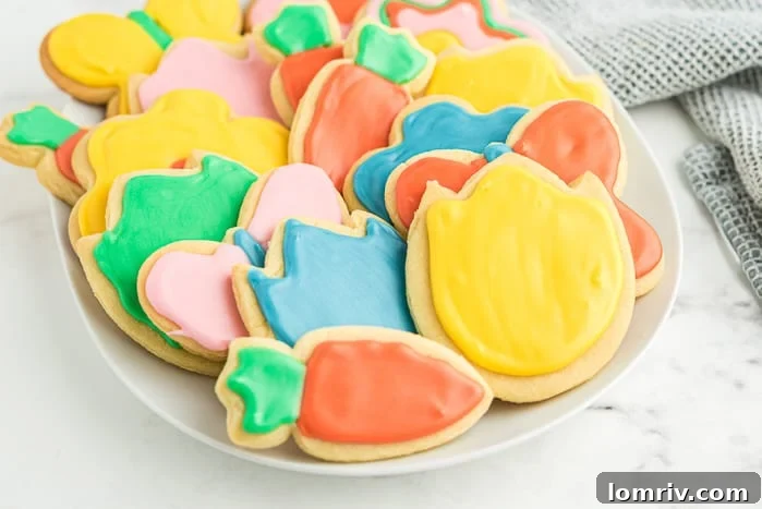 Children's hands decorating spring cookies with colorful royal icing