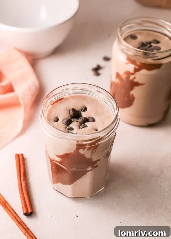 A glass of Banana Bread Smoothie with a straw, garnished with cinnamon