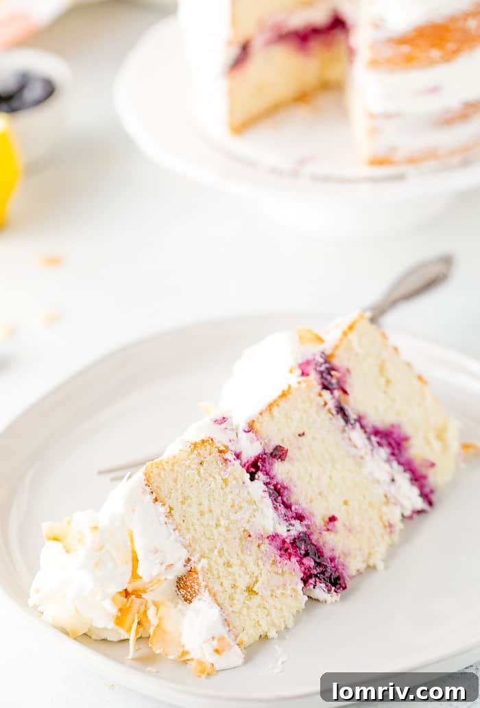 Slice of Coconut Blueberry Layer Cake showing moist layers and compote.