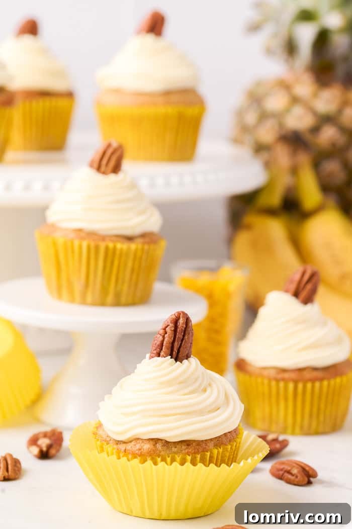 Classic Hummingbird Cupcakes with banana, pineapple, and pecans, topped with tangy cream cheese frosting.