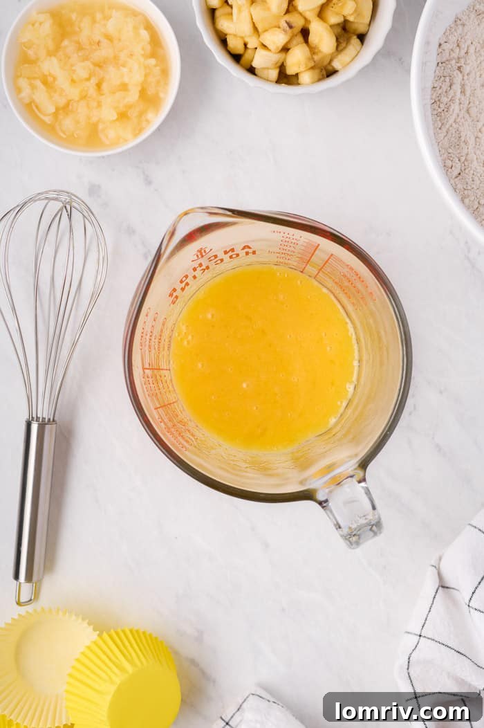 Wet ingredients for Hummingbird Cupcakes (oil, eggs, vanilla) whisked in a separate bowl.
