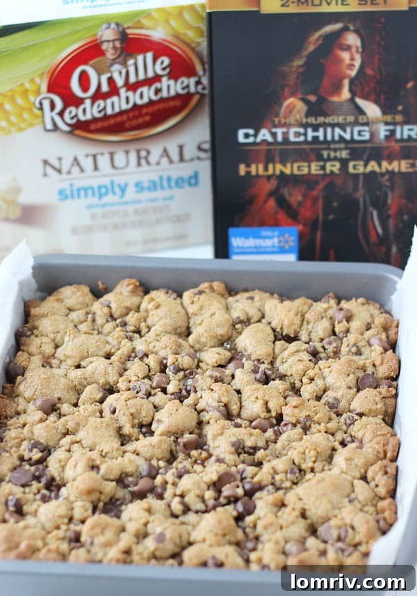 Close-up of a stack of Salted Caramel Twix Cookie Bars, showing the gooey caramel and chocolate chips