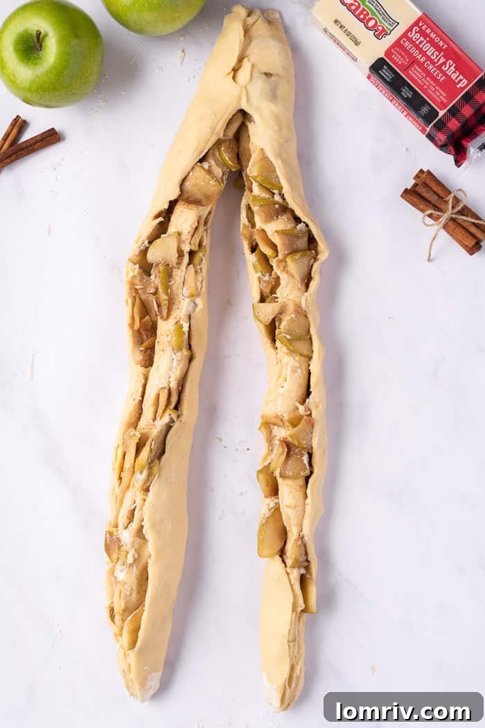 The technique of cutting the filled dough log lengthwise, leaving one end attached