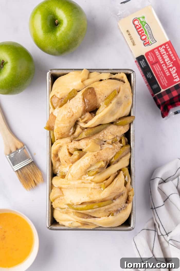 Apple Cheddar Twist Bread undergoing its final rise in the loaf pan