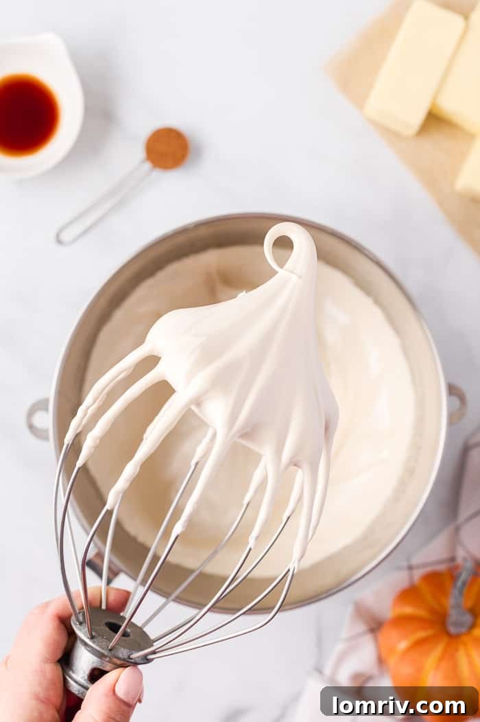 Fluffy Swiss meringue forming stiff peaks in a stand mixer