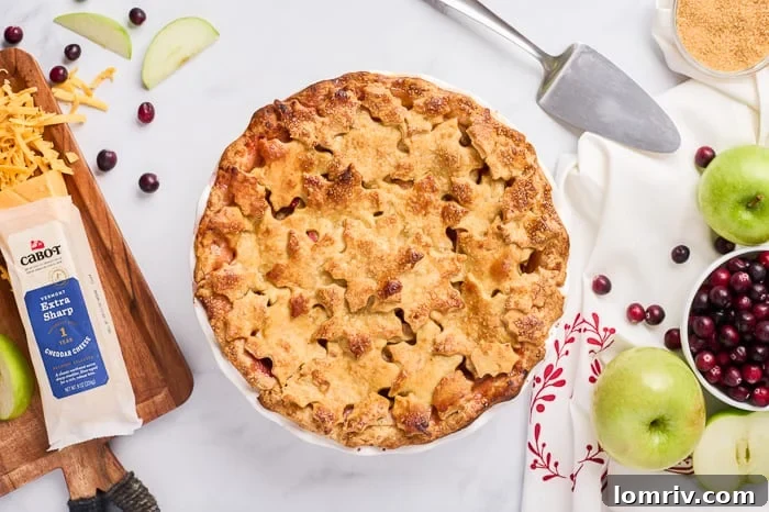A whole Apple Cheddar Cranberry Pie with a decorative top crust, ready to be served