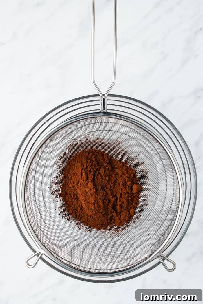 Sifting cocoa powder into a bowl
