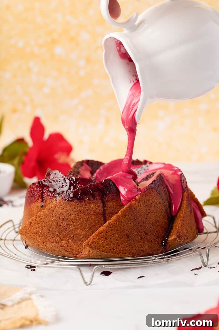 A beautifully sliced Fonio Pound Cake, showcasing the tender crumb and infused hibiscus color