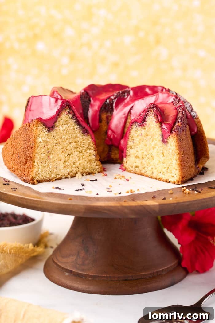 Fonio Pound Cake cooling on a wire rack, freshly glazed with the vibrant hibiscus topping