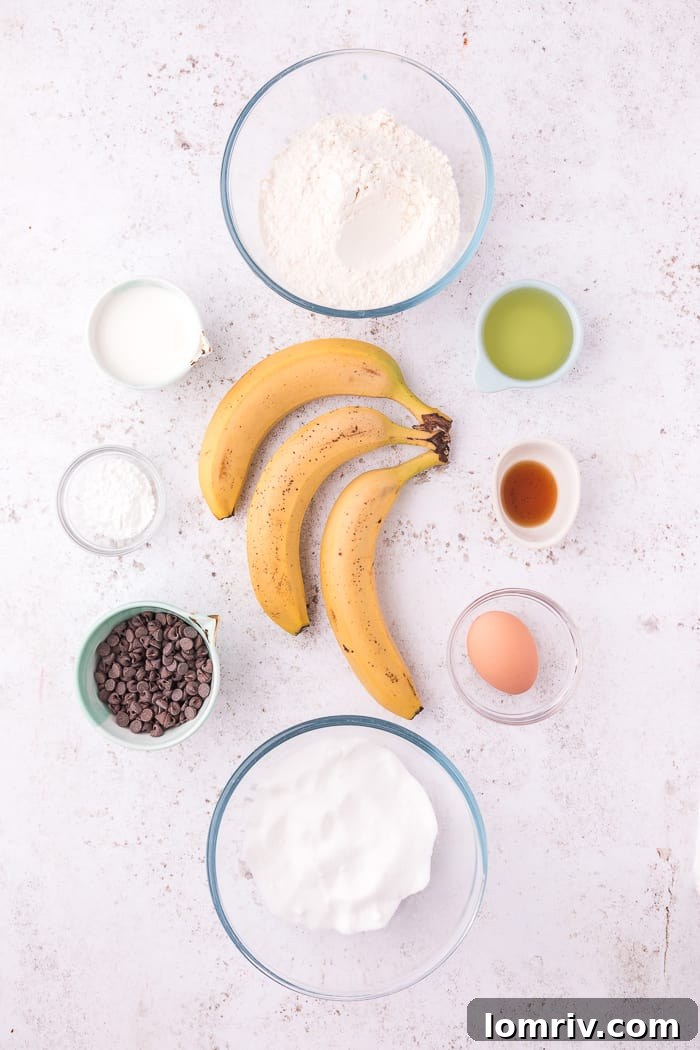 Fresh ingredients laid out for making Banana Chocolate Chip Muffins, including bananas, chocolate chips, flour, and eggs