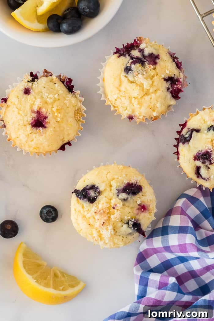 Lemon Blueberry Muffins cooling on a wire rack, showing off their golden tops