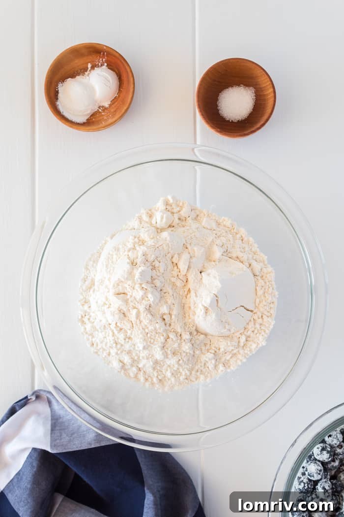 Blueberries being tossed with a tablespoon of flour