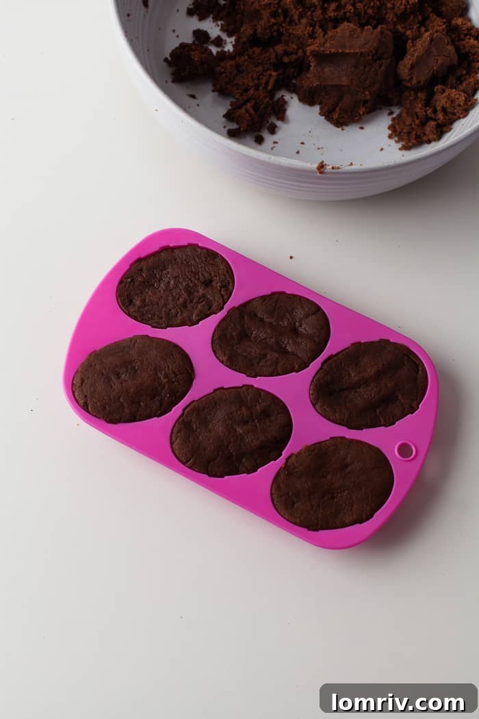 Egg-shaped cake pop molds filled with the cake mixture, ready for freezing.