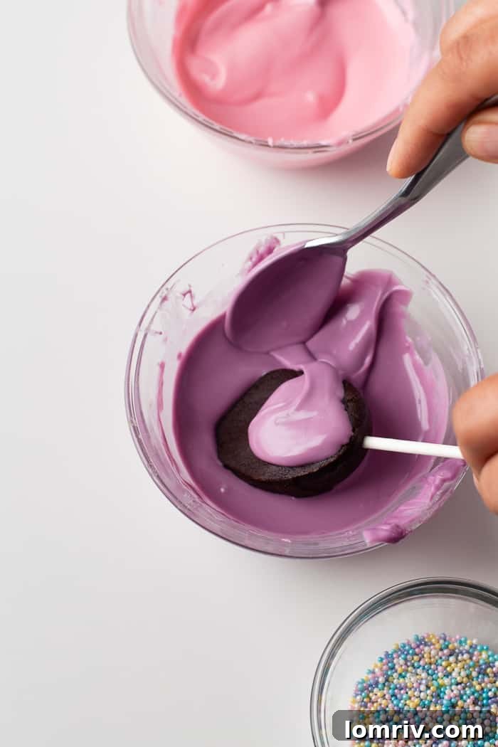 An Easter Cake Pop being covered with melted chocolate using a spoon.