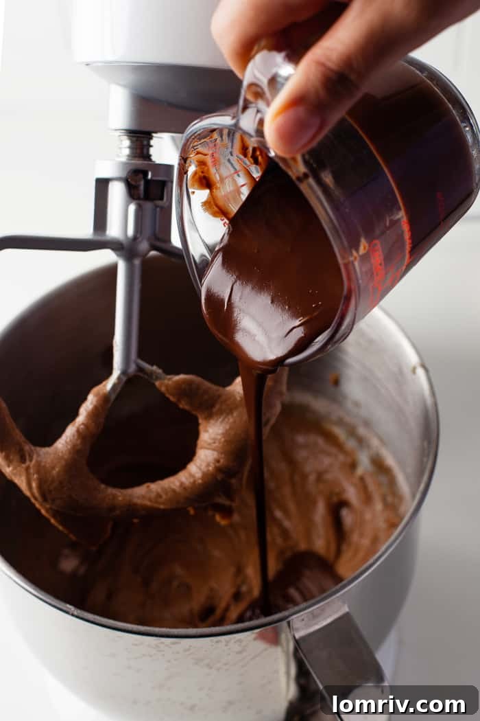 Melted chocolate being folded into the cake batter, adding richness.