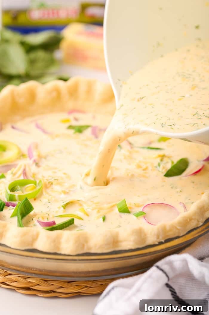 Layering vegetables and pouring egg mixture into the quiche crust