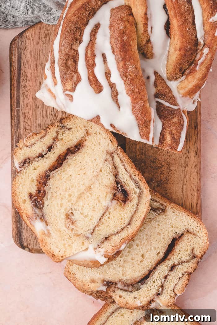 Cinnamon Swirl Bread sliced on a cutting board, ready to be enjoyed.