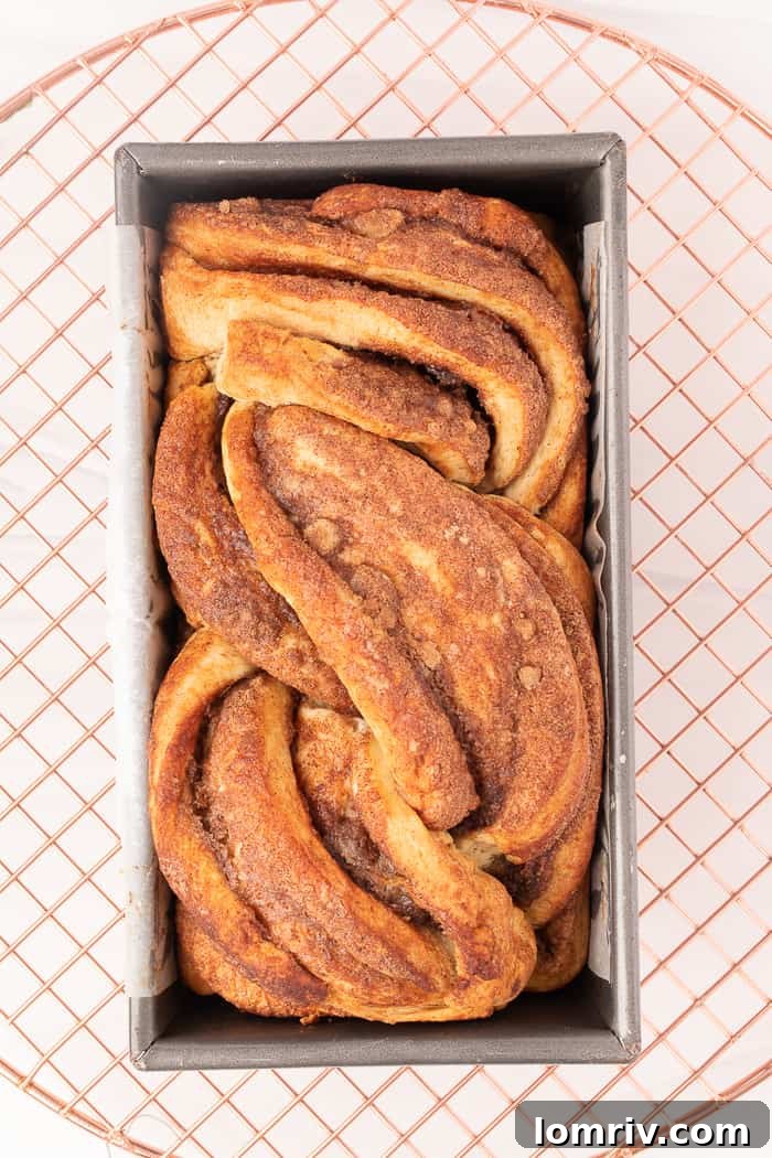 Freshly baked Cinnamon Swirl Bread cooling in its loaf pan.