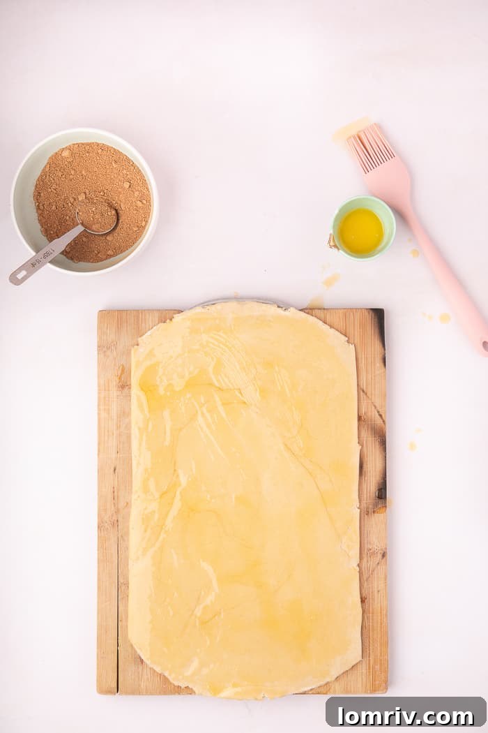 Melted butter being brushed onto the Cinnamon Swirl Bread dough.