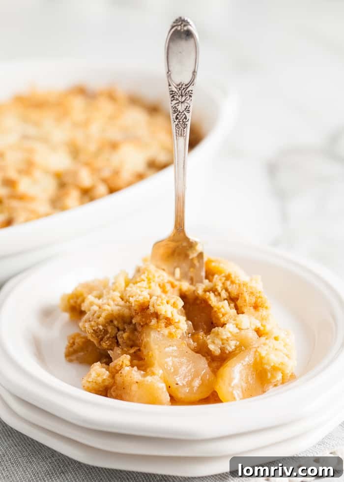 Easy Apple Cobbler on a plate with a fork in it, ready to be enjoyed.