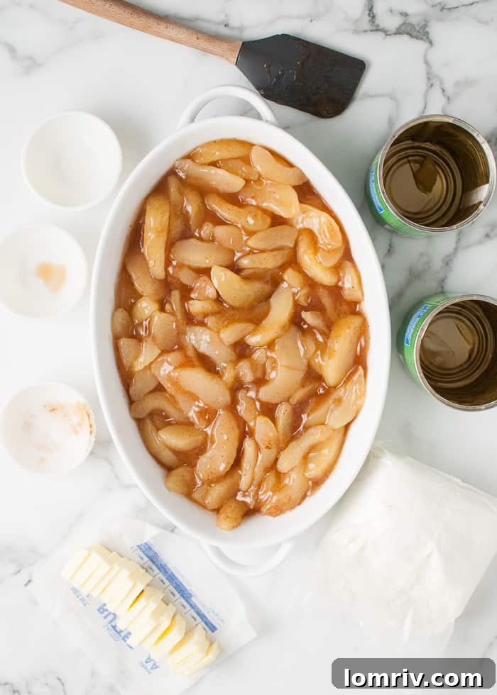 Spiced apple pie filling spread evenly in a casserole dish, ready for the cake mix.