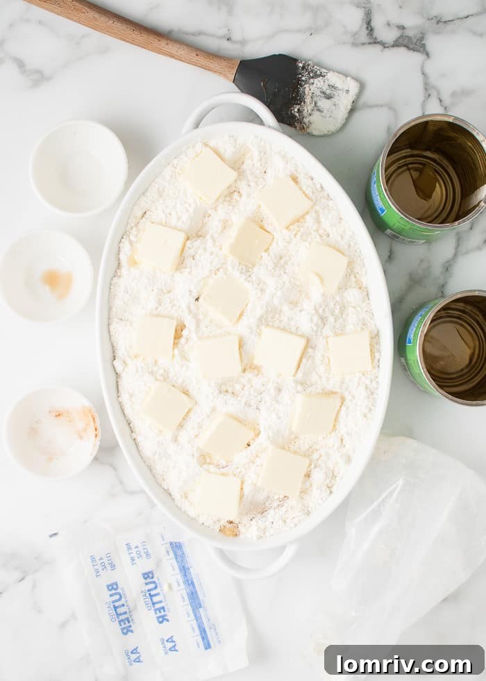 Butter cubes arranged on top of the cake mix layer for apple cobbler.