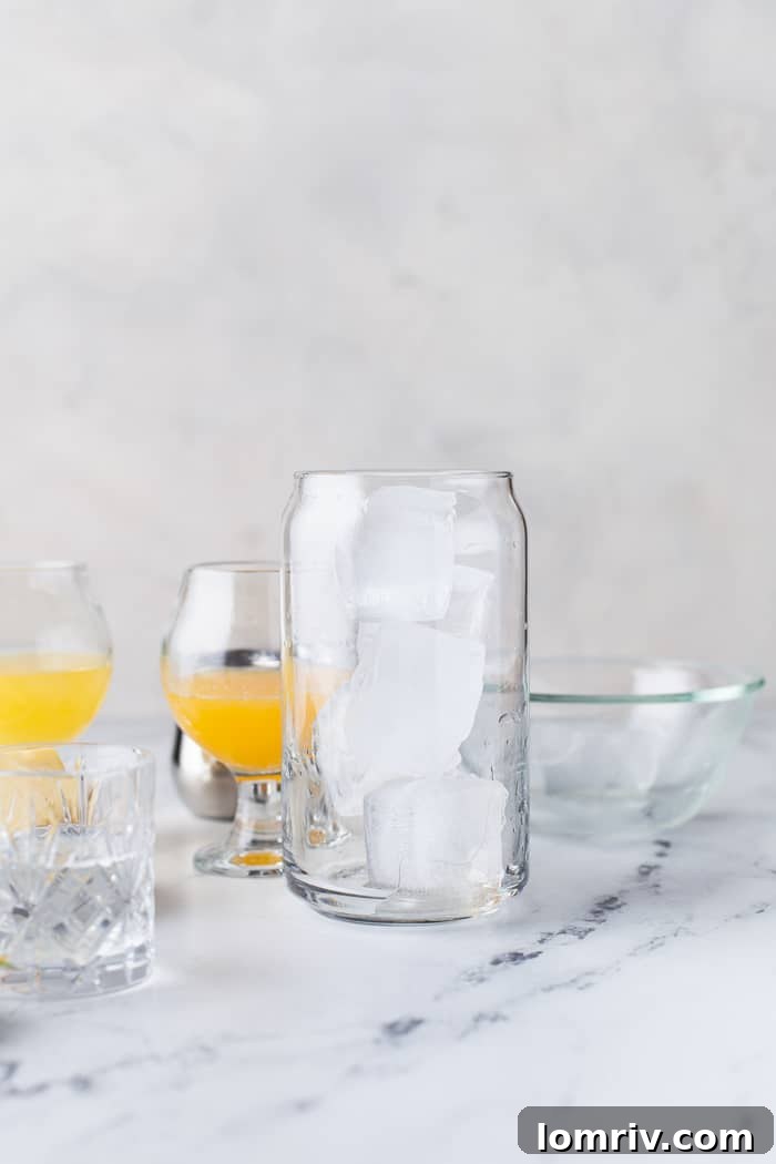 A tall glass filled with clear ice cubes, ready for cocktail preparation